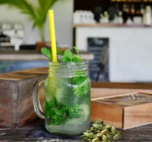 Aromatische Minz-Kardamom-Tee im Glas, ein erfrischendes Kräutergetränk mit ayurvedischen Zutaten für ein belebendes Erlebnis.
