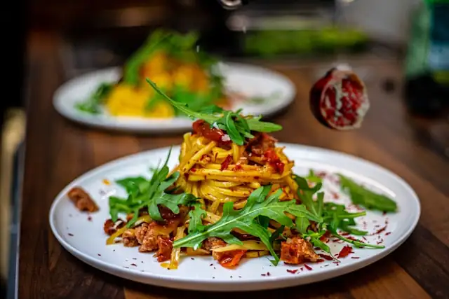 Köstliche Spaghetti mit Rucola und Granatapfel in einer würzigen Soße, ideal für ein gesundes, aromatisches Abendessen.